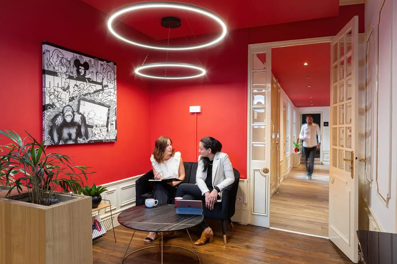 Deux collaboratrices du Studio Ikadia en plein échange dans le petit salon de l'agence