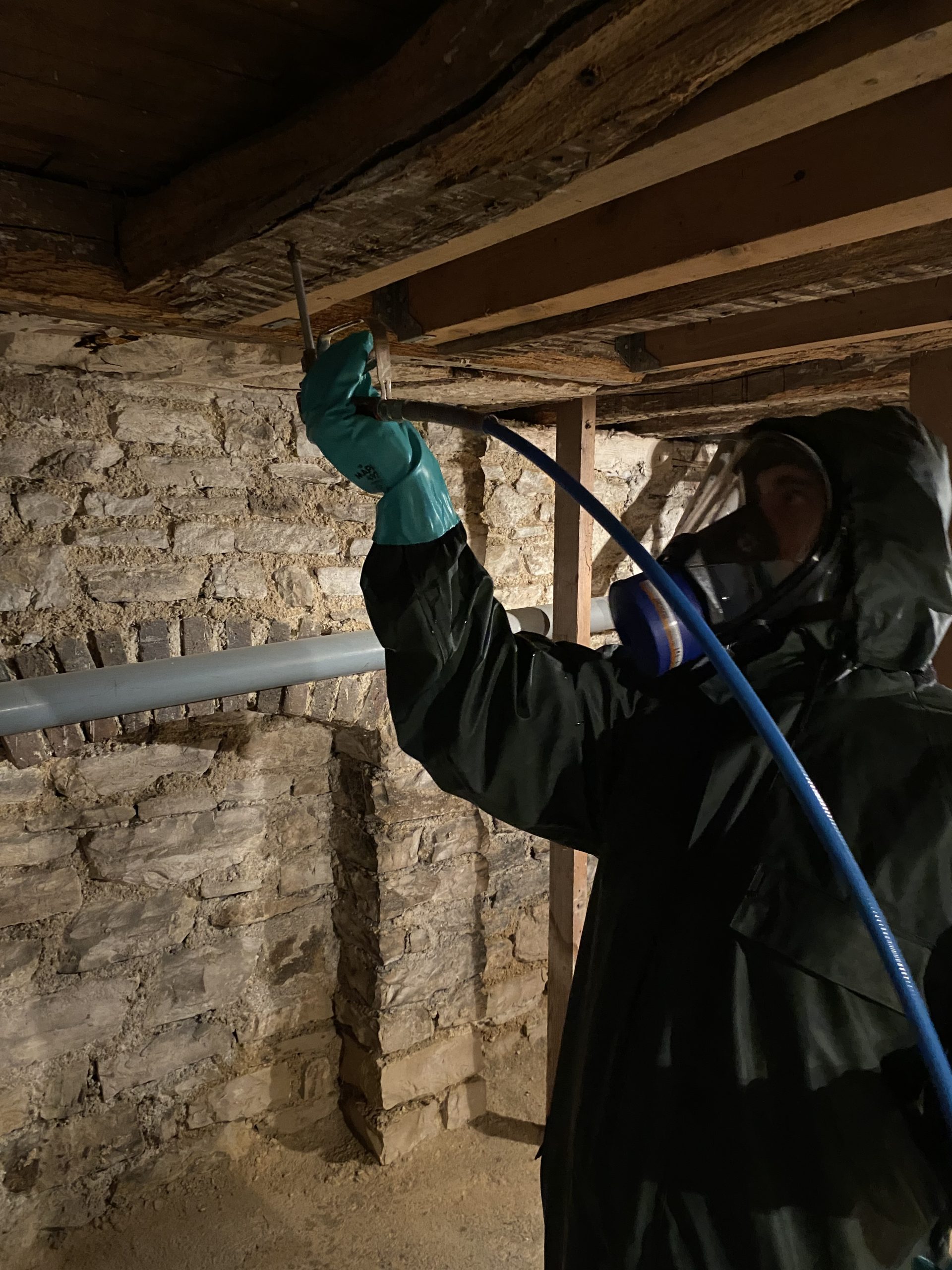 Technicien Asturat injectant un produit de traitement dans une poutre bois